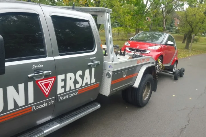 Universal Roadside Assistance tow truck transporting a vehicle